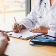 Diskussion zum Thema "Ambulante Gesundheitsversorgung im Landkreis Zwickau" | Bild: Eine Ärztin mit Stethoskop sitzt am Schreibtische einem Patienten gegenüber. Die Gesichter der Personen sind nicht zu sehen.