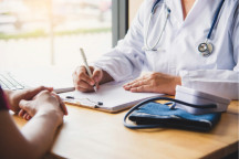 Diskussion zum Thema "Ambulante Gesundheitsversorgung im Landkreis Zwickau" | Bild: Eine Ärztin mit Stethoskop sitzt am Schreibtische einem Patienten gegenüber. Die Gesichter der Personen sind nicht zu sehen.